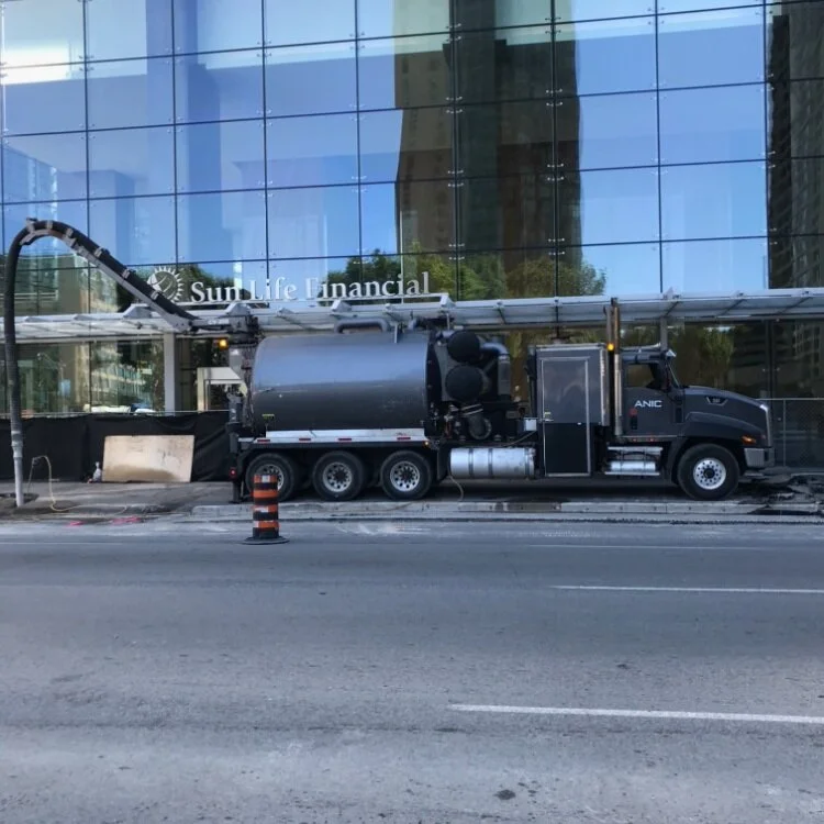 An ANIC hydro vac truck working outside a downtown Toronto office tower